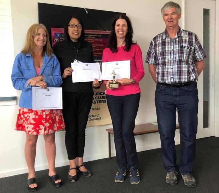 Photo of speech contest winners holding their certificates, with contest chief judge.